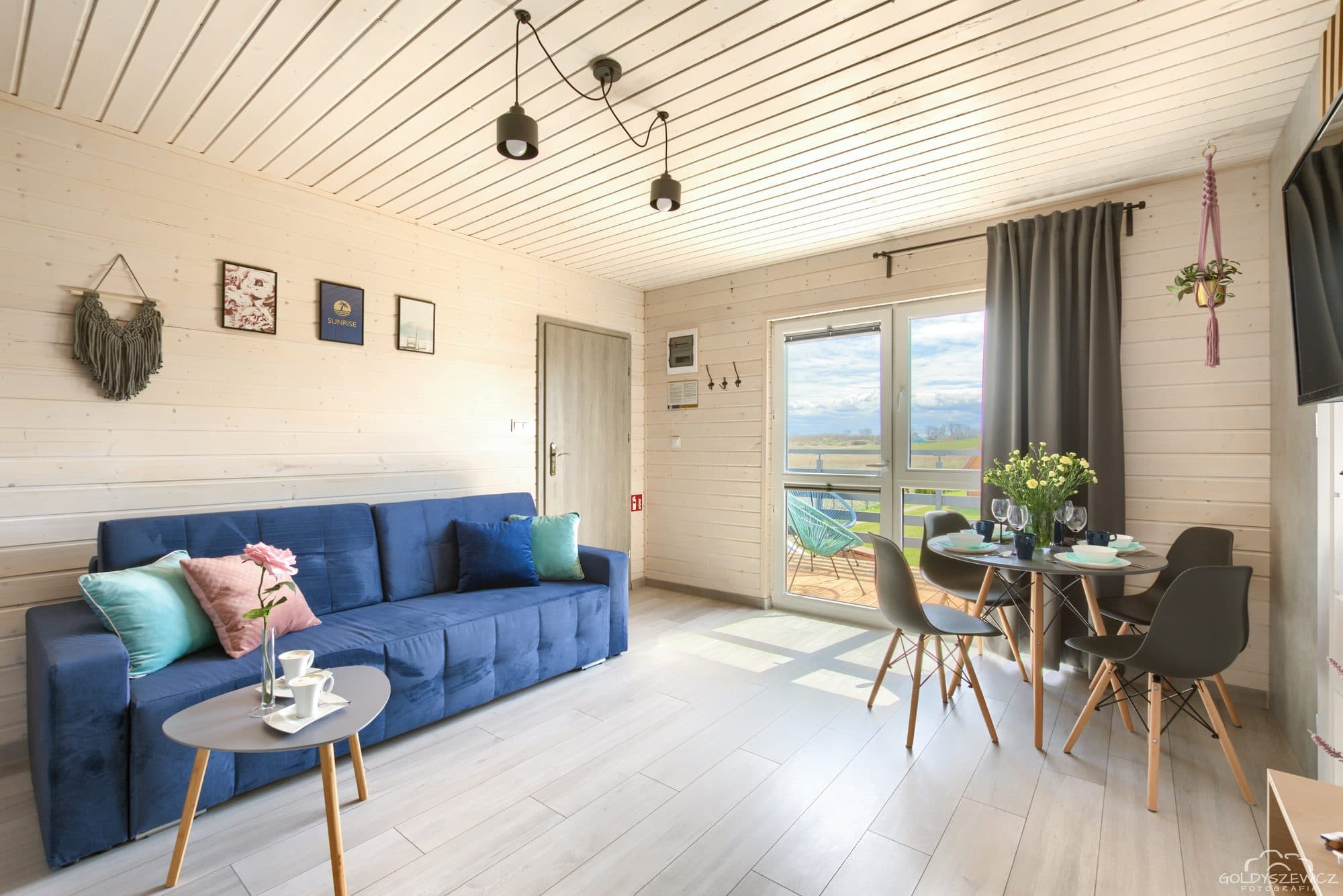 Salon apartamentu na piętrze w Sarbinowie z sofą i wyjściem na balkon