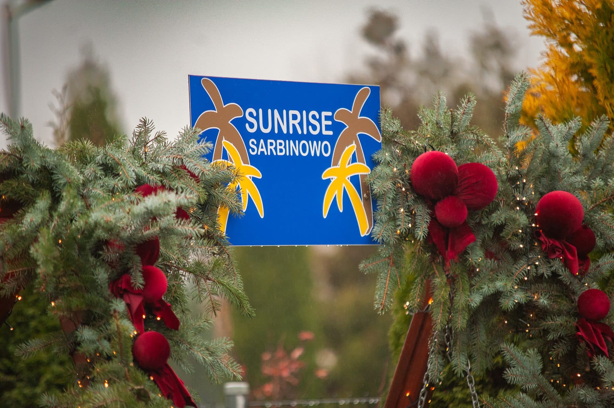 Christmas garland with baubles on the Sunrise Sarbinowo sign